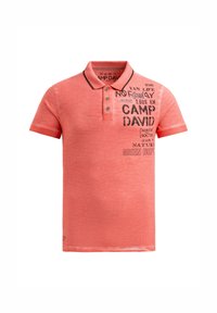 Coral short-sleeve polo shirt with buttoned collar and black printed text and graphics on the upper left chest.