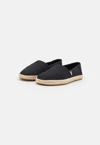 Scarpe slip-on in tela nera con tomaia testurizzata e suola in juta intrecciata, dotate di punta affusolata e dettagli di cucitura minimal.