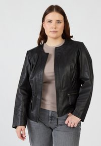 Schwarze Lederjacke mit tailliertem Design, Reißverschlusstaschen und rundem Kragen. Glatte Textur, maßgeschneiderte Passform und subtile Nähdetails.
