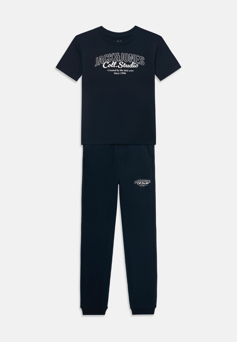 Completo jogger navy che include una t-shirt a maniche corte con stampa del logo bianca e pantaloni coordinati con vita elasticizzata e caviglie elastiche.
