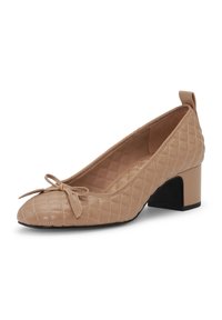 Beżowy pikowany but na niskim obcasie, z zaokrąglonym noskiem, kokardą z przodu oraz czarnym, szerokim obcasem, wyposażony w pętelkę z tyłu kołnierza buta.