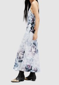 Blommig maxiklänning med lätt tyg, pastellfärger och intrikata blomster mönster. Svarta ankelstövlar med gulddetalj vid tån.