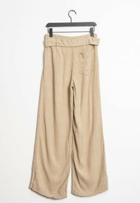 Pantalones de pierna ancha beige hechos de una tela suave. Cuentan con una cintura con cinturón, bolsillos laterales y un bolsillo trasero. Textura suave en toda su superficie.