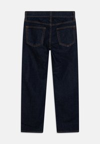 Mørkeblå denimjeans med rett ben, to bak lommer og oransje søm detaljer. Glatt tekstur med et klassisk design.