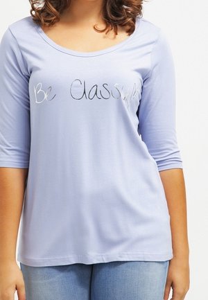 Lyslilla langærmet T-shirt med en rund halsudskæring. Har sølvtekst "Be Classy" hen over fronten. Blødt bomuldsstof.