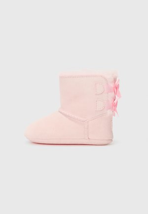 Rosa Wildleder-Stiefelette mit weicher Fütterung, ausgestattet mit zwei dekorativen Riemen und Schleifen an der Seite. Rundspitze und flache Sohle für Komfort.