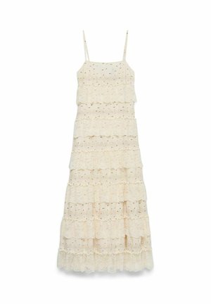 Robe longue en dentelle sans manches couleur crème avec des couches à volants en forme de coquillage et de fines bretelles ajustables.
