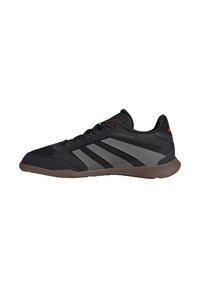 Zwarte sportieve schoenen met bovenwerk van mesh en synthetisch materiaal, grijze accenten, uitgerust met drie strepen, rubberen zool en afgeronde neus.