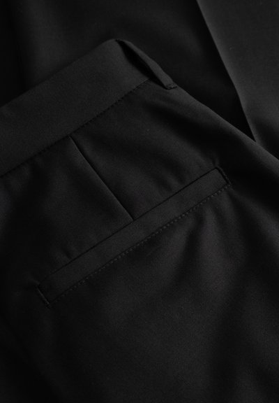 Sorte bukser i stof med en glat tekstur, skræddersyet design og en enkelt baglomme med pæn syningsdetalje.