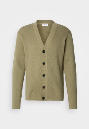 Olivgrön ribbad cardigan med V-ringning, knäppning fram och långa ärmar. Har fem svarta knappar och en texturerad yta.