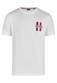 Witte katoen t-shirt met ronde hals, korte mouwen en een logo aan de voorkant met rode en marineblauwe accenten. Minimalistisch ontwerp.
