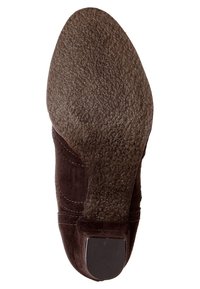 Suola di scarpa in suede marrone con superficie texturizzata, tacco leggermente rialzato e accentuazione rettangolare sul retro del tacco.