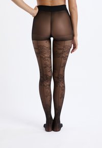 Transparante zwarte panty met florale kanten patronen, hoge tailleband, een lichte glans en een gladde textuur, die de benen van taille tot voeten bedekt.
