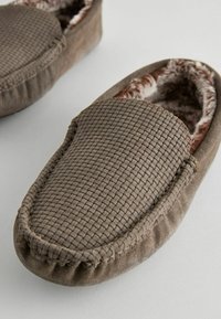 Brune vævede slippers med en blød, puddet foring. Rund tå, syede detaljer og et komfortabelt slip-on design. Tekstureret overflade.