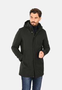 Cappotto impermeabile nero con cappuccio, dotato di chiusura con zip e bottoni a pressione, progettato con due tasche laterali e una vestibilità dritta.