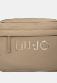 Borsa sintetica beige con texture liscia, logo "LIU·JO" in rilievo, chiusura con zip e dettagli di cucitura sottili.