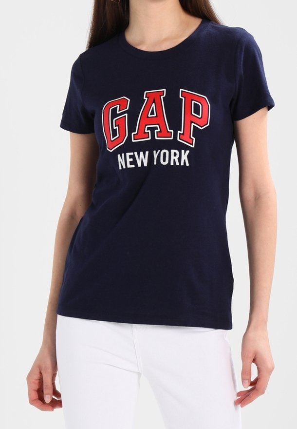Námořnická modrá bavlněná tričko s krátkým rukávem, na přední straně má vytištěné červené nápisy "GAP" a "NEW YORK". Klasický design s kulatým výstřihem.