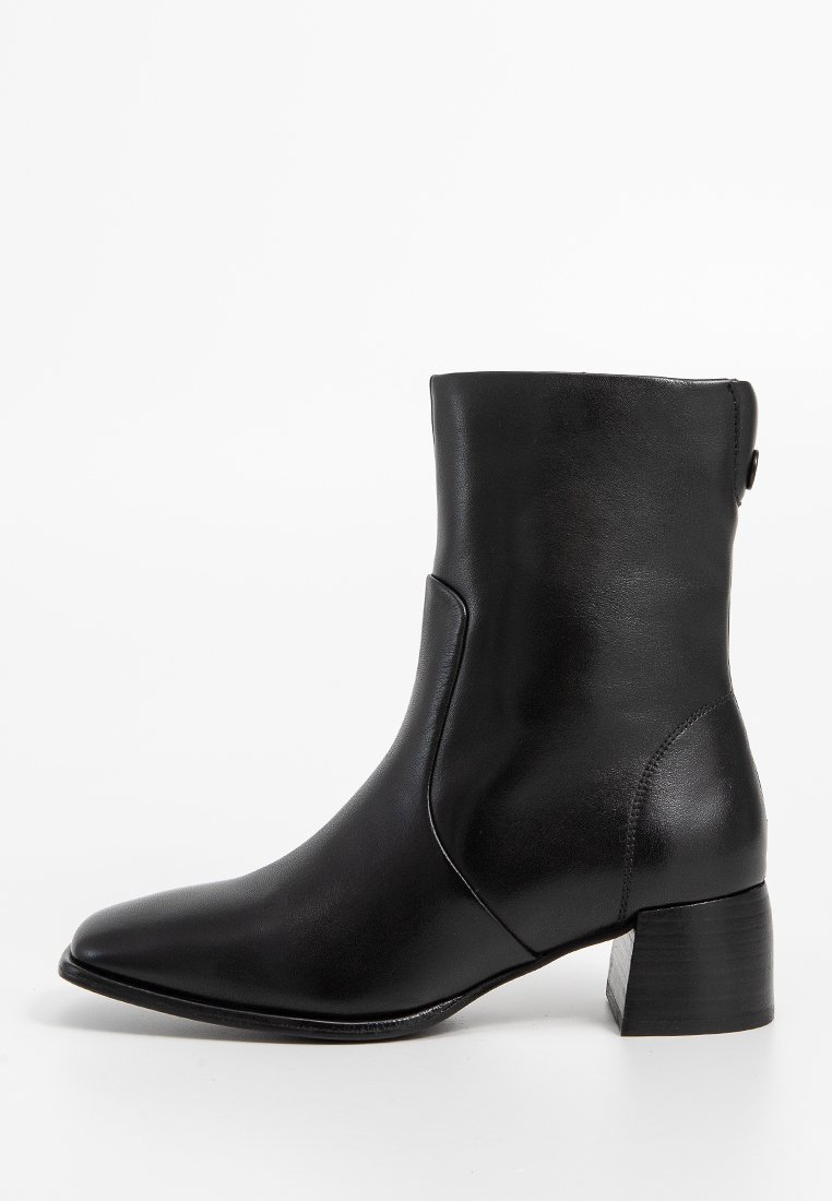 Stivale alla caviglia in pelle nera con punta affusolata, tacco a blocco di altezza media, superficie liscia e dettagli di cucitura sottile sul lato.