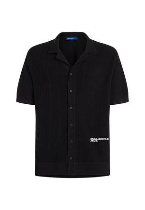 Lyhythihainen musta poolopaita, jossa on teksturoidusta kankaasta tehty edusta, napit, terävä kaulus ja oikeassa alakulmassa valkoinen "Karl Lagerfeld Jeans" -logo.