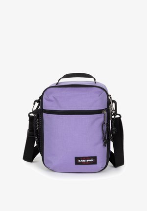Mała prostokątna fioletowa torba na ramię z czarnym regulowanym paskiem, przednią kieszenią na zamek, górną rączką i naszywką z logo Eastpak.