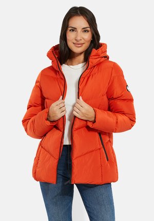 Opblaasjack in feloranje met een capuchon, voorzien van een gequilt ontwerp, zwarte ritsaccenten en zijzakken, gedragen over een wit topje.
