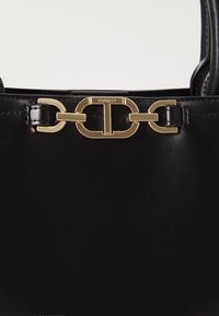 Black leather handbag with gold-toned chain link hardware and logo, featuring a smooth texture and structured design.
