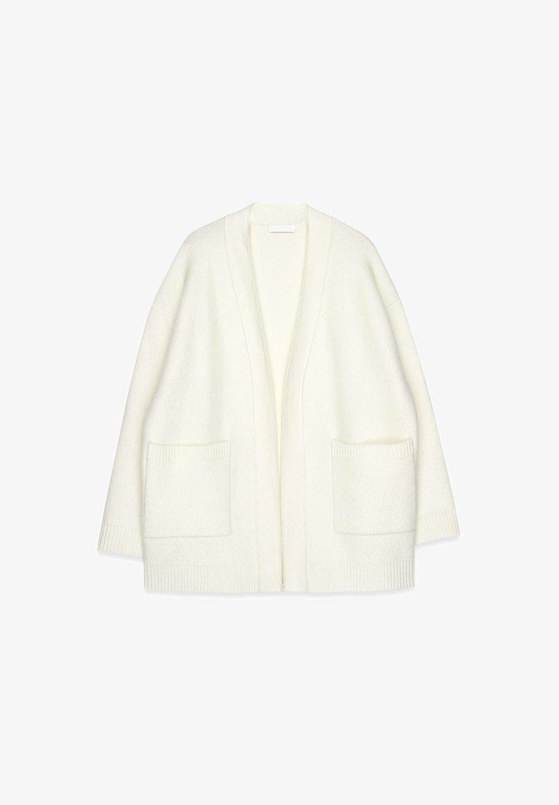 Witte gebreide cardigan met een open voorkant, brede mouwen, twee zakken aan de voorkant en geribbelde accenten aan de randen. Zachte textuur en een ruime pasvorm.