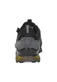 Zwarte en grijze sneaker gezien van achteren met "CRUYFF" op de zool en "FEARMA" op de hiel trekband.