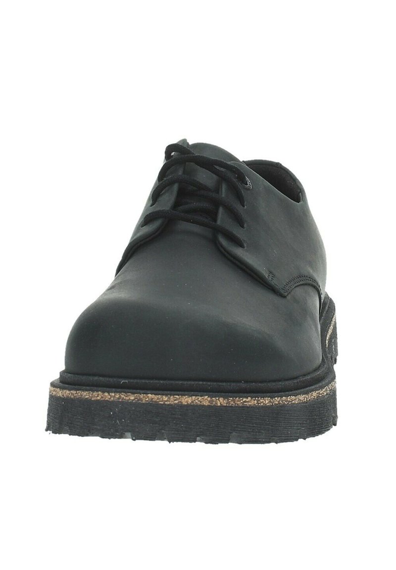 Schwarze Leder-Schnürschuhe mit runder Zehenform, strukturiertem Obermaterial und einer dicken Gummisohle mit einer Korkschicht und rutschfestem Muster.