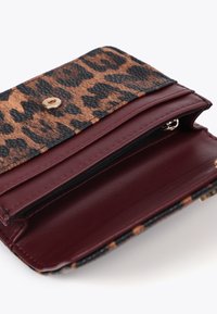 Portafoglio con stampa leopardata, flap a motivo nero e marrone e interno bordeaux con scomparto con zip e chiusura a scatto oro.