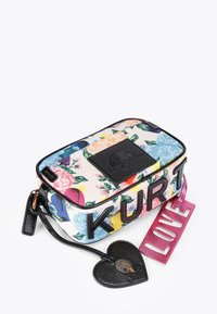 Sac rectangulaire à motif floral avec accents en cuir noir, arborant "KURT" en lettres noires audacieuses et une étiquette "LOVE" rose.
