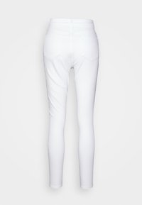 Calças skinny brancas com uma textura suave e elástica, apresentando dois bolsos traseiros e uma cintura alta, desenhadas para um ajuste confortável.