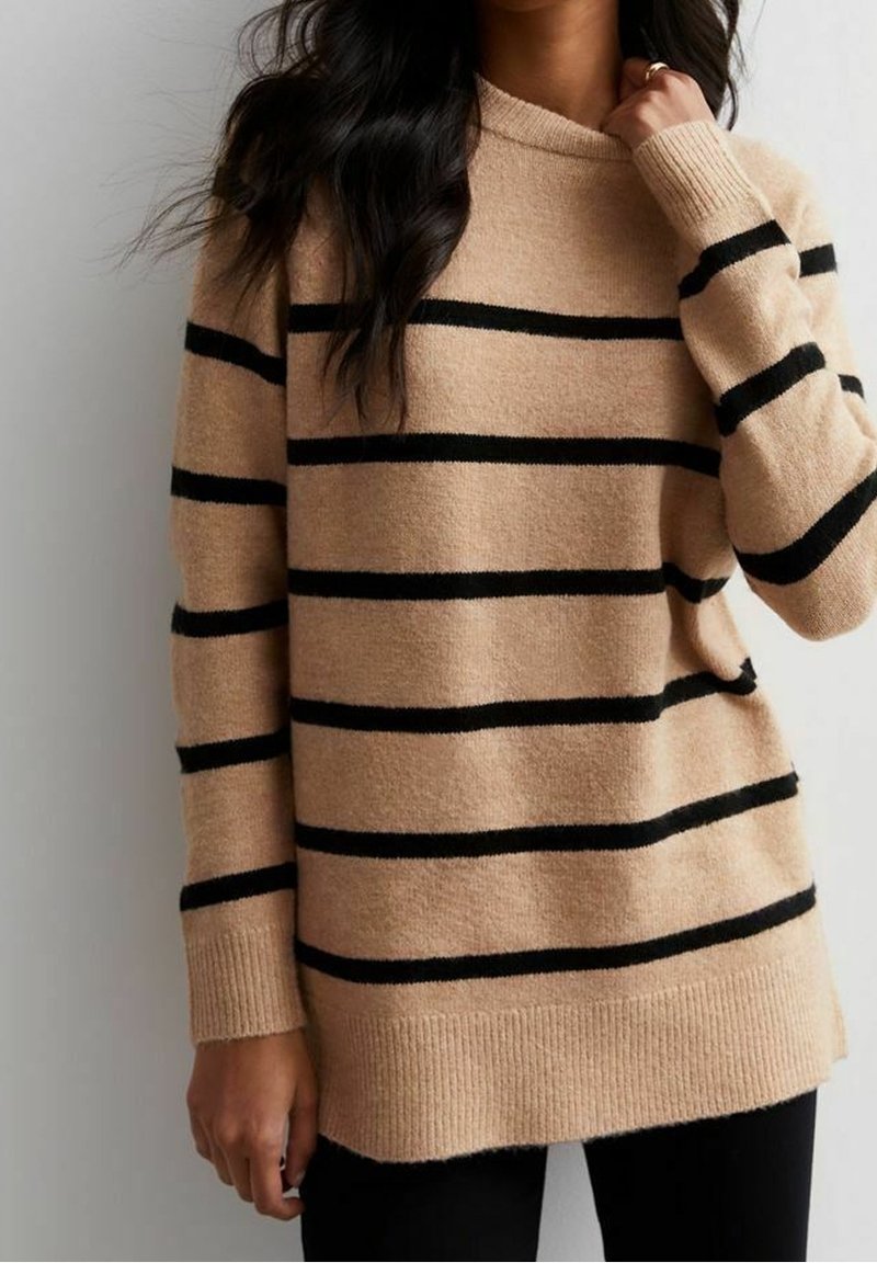 Beige tröja med horisontella svarta ränder, gjord av mjukt tyg. Har en rund halsringning och långa ärmar, med ribbade muddar och nederkant.