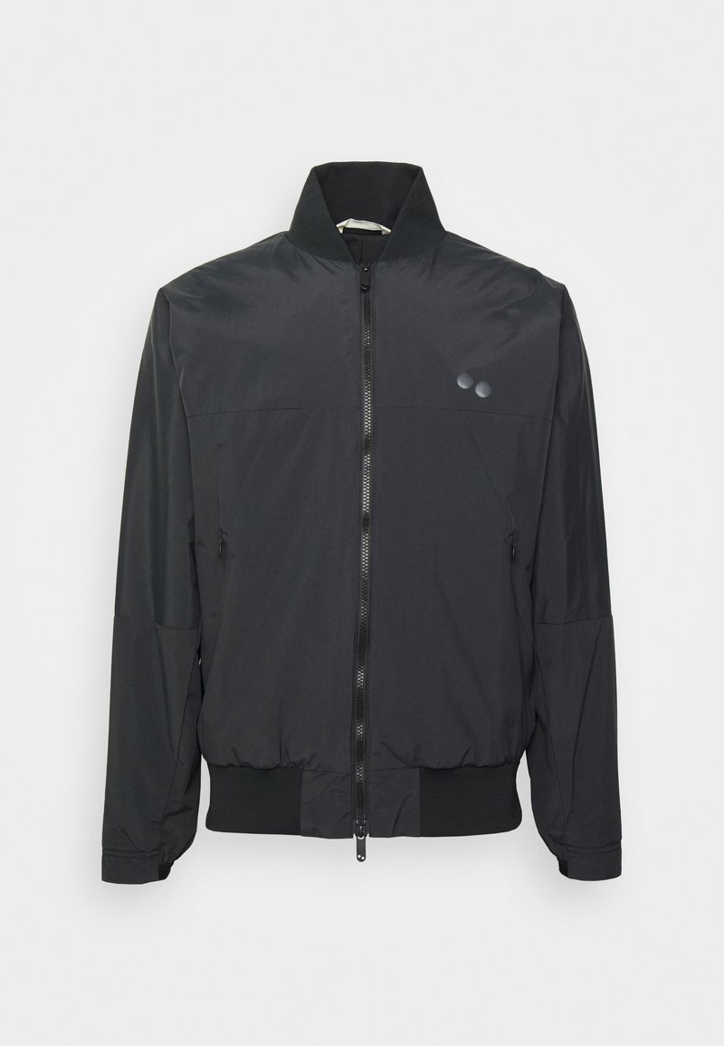 Schwarze Bomberjacke mit hohem Kragen, Reißverschluss vorne, elastischen Bündchen und Saum. Verfügt über zwei dezente Logo-Highlights auf der Brust. Leichtes Material.