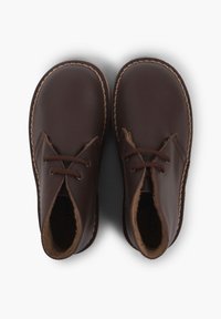 Scarpe di pelle marrone con punta arrotondata, fodera in suede e cuciture a contrasto. Presentano lacci tradizionali per una vestibilità sicura.