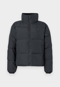 Μπουφάν με φερμουάρ σε μαύρο χρώμα με ψηλό γιακά, που διαθέτει οριζόντιες ραμμένες ενότητες και στρογγυλή ετικέτα λογότυπου στο στήθος.