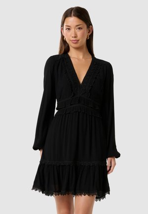 Black dress with a deep V-neck, long sleeves, and layered ruffles. Features lace accents at neckline and hem. Flowy silhouette.