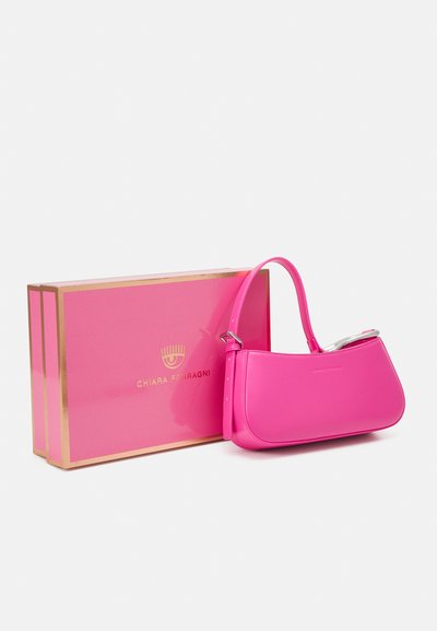 Borsa in pelle rosa con una forma curva, tracolla corta e accessori in argento. Accompagnata da una scatola rosa abbinata con dettagli dorati.