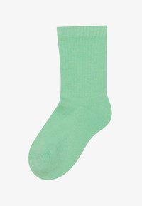 Meta zelena, rebrasta bombažna nogavica s izrazitim robom. Oblikovanje vključuje gladko teksturo in klasično višino do gležnja.