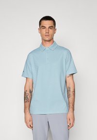 Light blue short-sleeve polo shirt with a patterned design, two-button collar, and a slightly loose fit. Fabric texture appears soft.