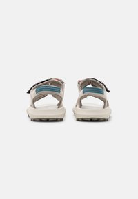 Sandalias de color gris claro con correas ajustables, que presentan acentos en turquesa y una suela texturizada para mayor tracción. Diseño abierto en la parte posterior para transpirabilidad.