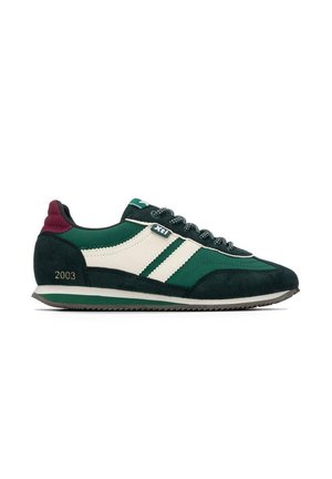 Zapatilla deportiva baja de color verde oscuro y blanco con cordones negros y blancos, detalle en el talón color granate y "2003" impreso cerca de la suela sobre un fondo blanco.