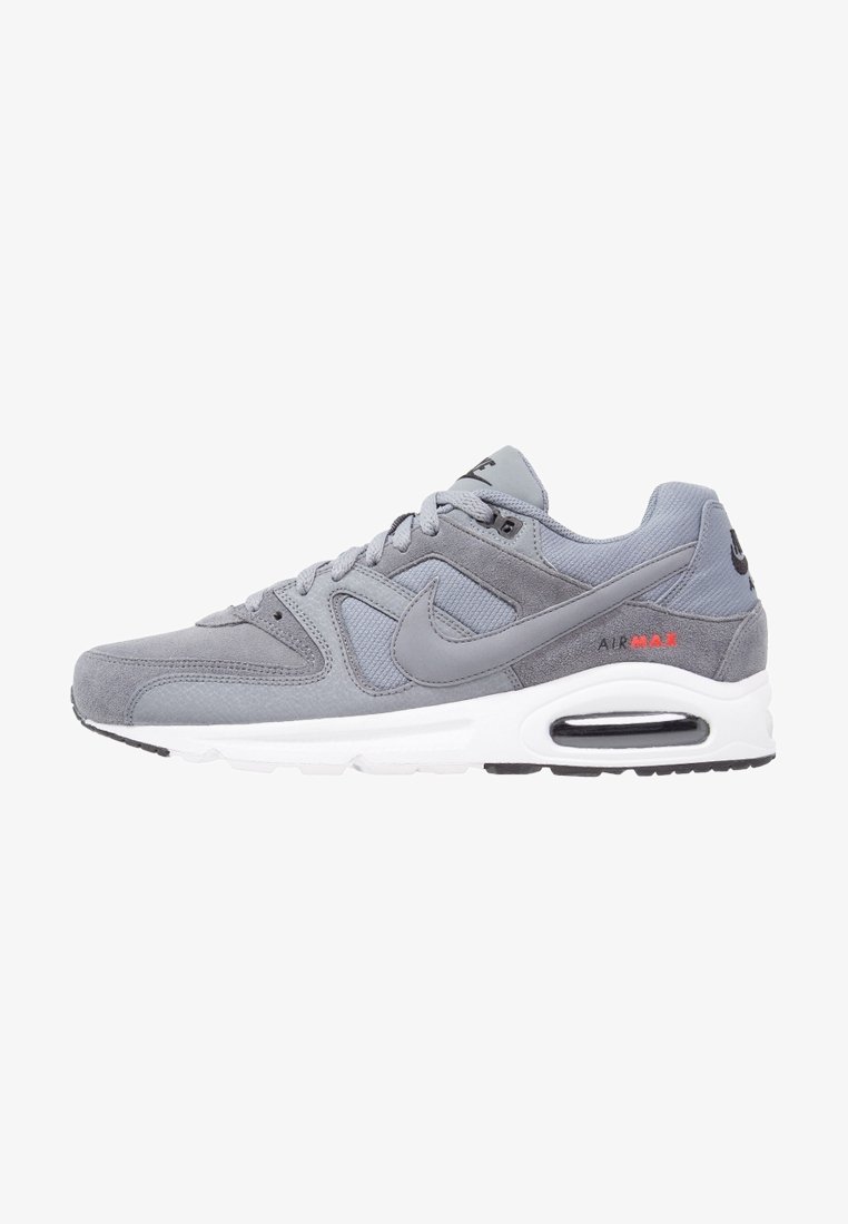 Gray Nike Air Max sneakers with suede and mesh materials, featuring a white midsole, black outsole, and red accent on the heel.