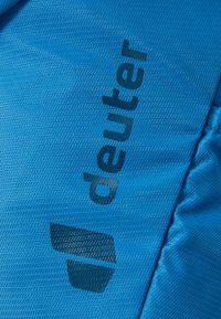 Light blue fabric with a textured surface, featuring the dark blue logo "deuter" and a geometric icon.