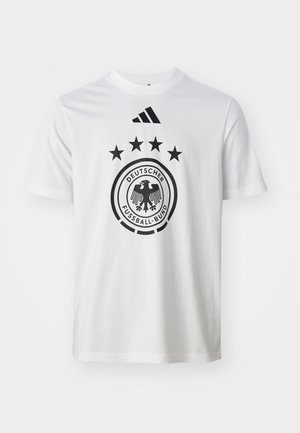 Fehér pamut póló, fekete kör alakú logóval, amelyen a "DEUTSCHER FUSSBALL-BUND" felirat szerepel, öt csillag felette, és három fekete csík a galléron.