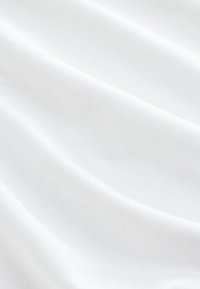 Tejido blanco de fibra entrelazada que presenta una superficie lisa y ligeramente texturada con sutiles ondulaciones y pliegues. Ideal para diversas aplicaciones textiles.