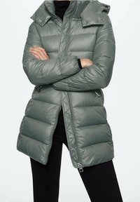 Hellgrüne Steppjacke mit horizontalen Nähten, Reißverschluss, verstellbarer Kapuze und Seitentaschen. Das Material wirkt glatt und glänzend.