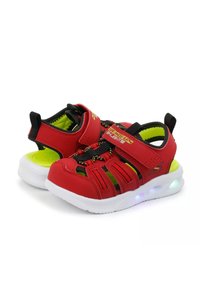 Zapatillas deportivas rojas con correas ajustables, detalles de malla y suelas blancas. Presenta luces LED multicolores en la suela y acentos en verde brillante.