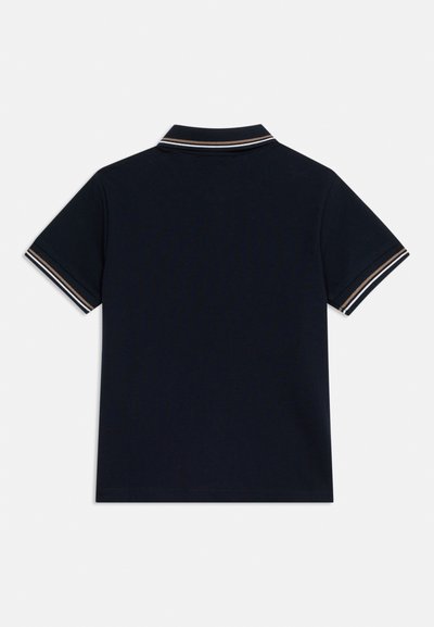 Πόλο μπλε ναυτικού με κοντά μανίκια, με λευκή και καφέ ριγέ λεπτομέρεια στη γιακά και στις άκρες των μανικιών, εμφανιζόμενο από την πίσω πλευρά.