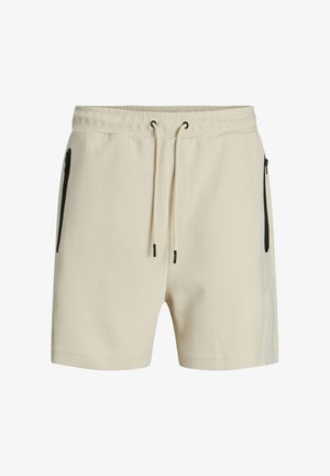 Pantaloni shorts beige realizzati in tessuto morbido, con una cintura elastica regolabile tramite un cordino e due tasche laterali nere con zip.